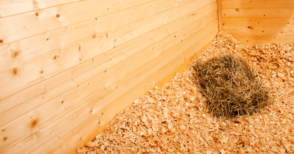 person using hands to add wheat straw to raised bed