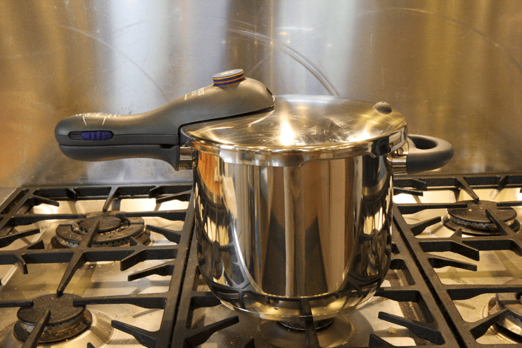 pressure cooker on stovetop for mushroom growing sterilization